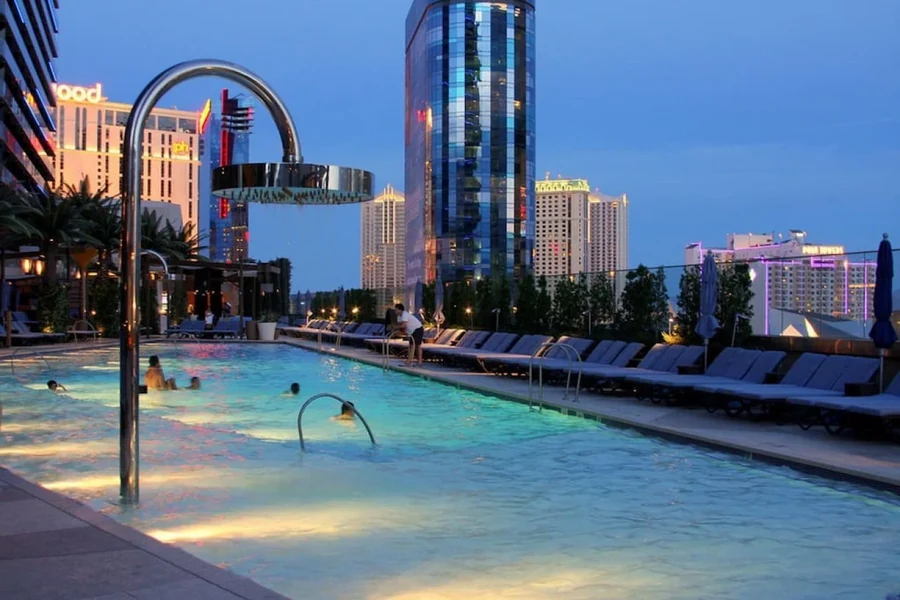 Outdoor pool with lounge chairs, palm trees and high-rises