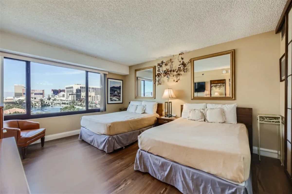 Las Vegas bedroom with two beds, framed artwork and a city view