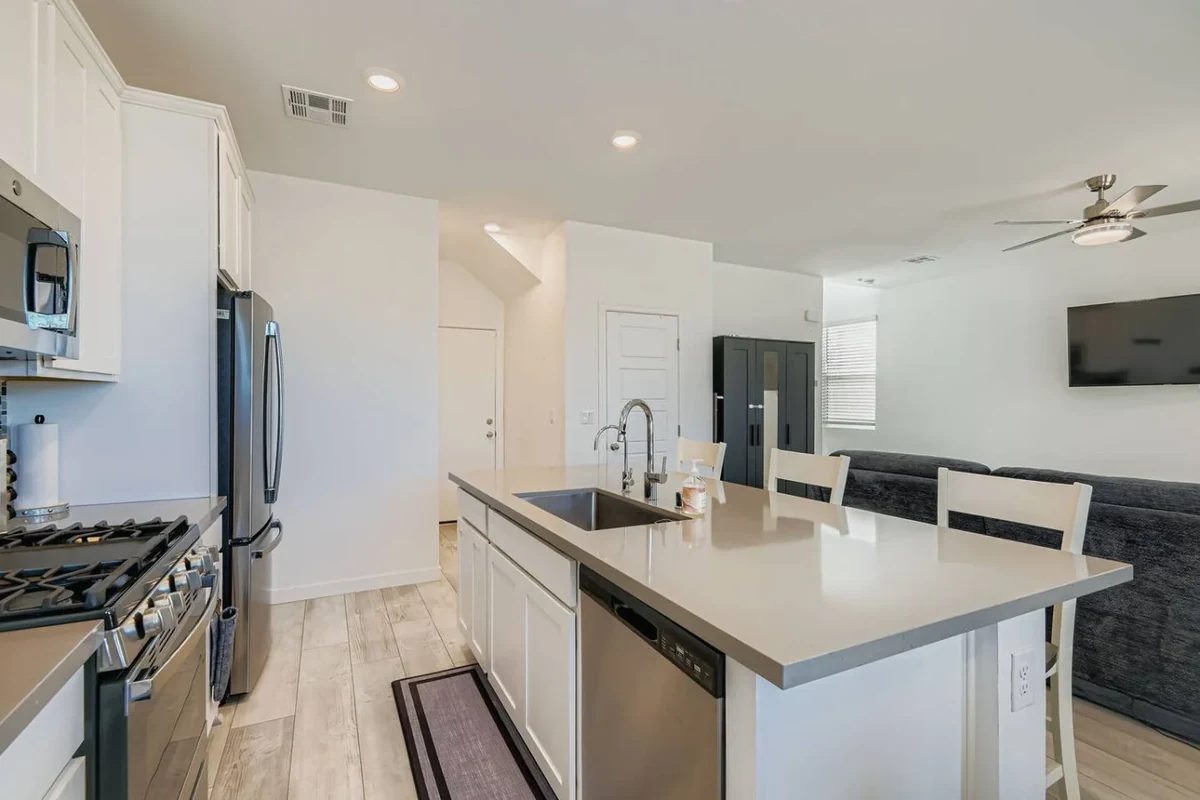 Las Vegas home kitchen with a white island, pendant lights and stainless appliances